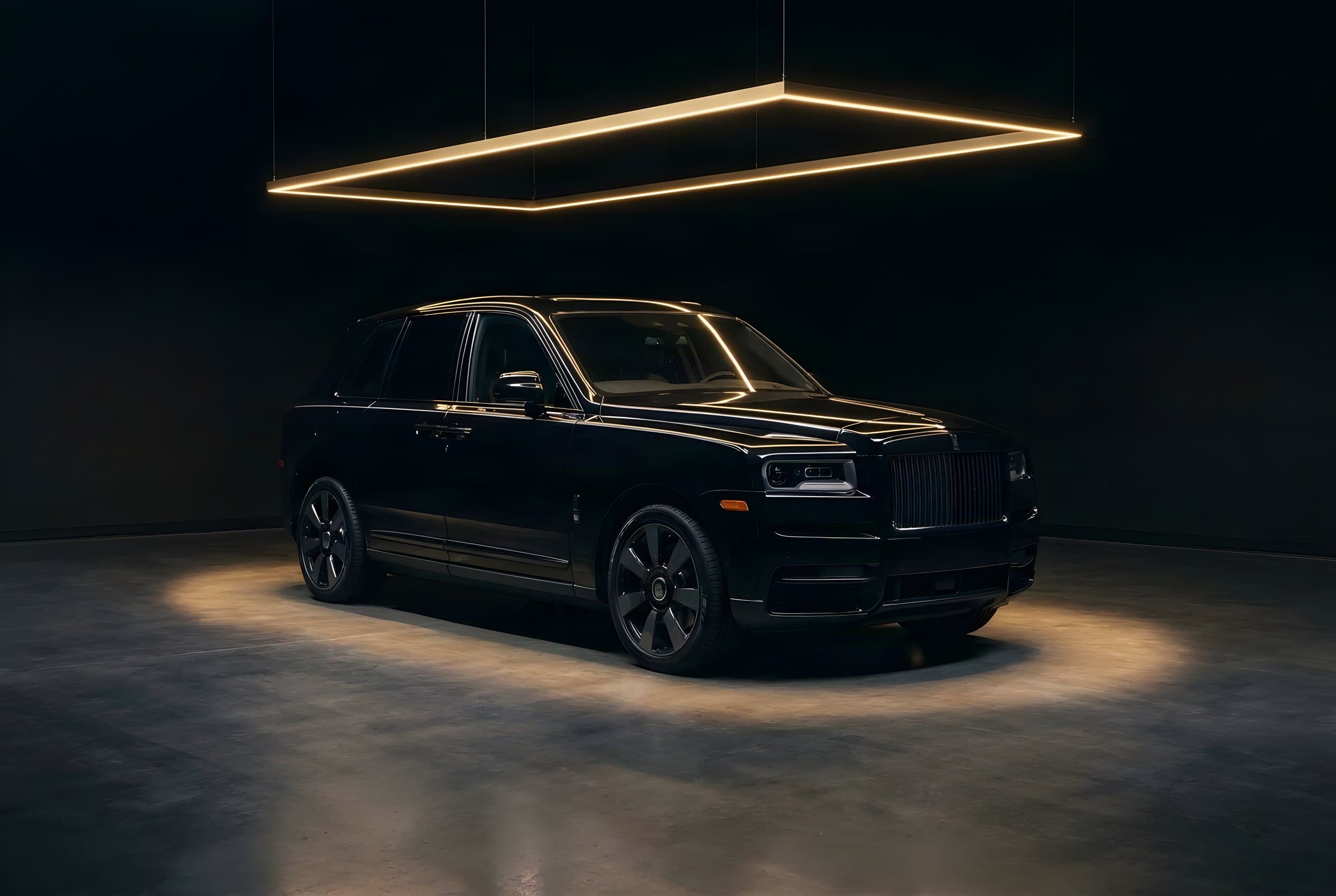 Black Rolls-Royce Cullinan in a pool of light beneath a golden light frame